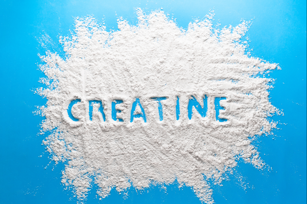 creatine powder on counter with creatine spelled in the powder