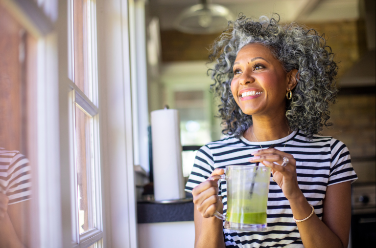 middle aged women smiling and drinking green juice